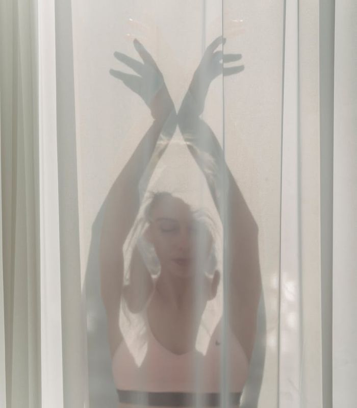 Woman meditating in a peaceful yoga pose, bathed in soft light.